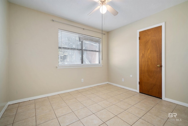 tiled spare room featuring ceiling fan