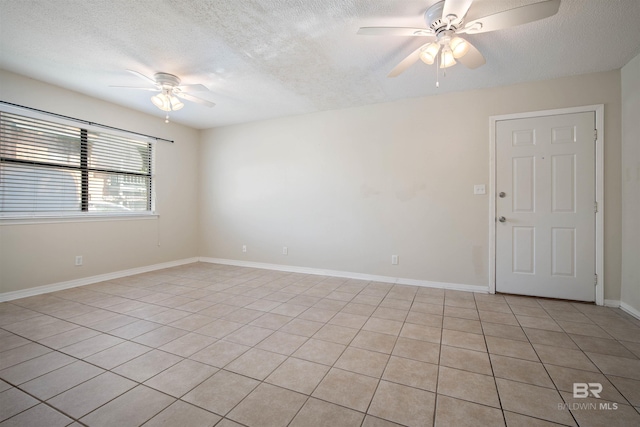 spare room with ceiling fan, a textured ceiling, and light tile patterned flooring