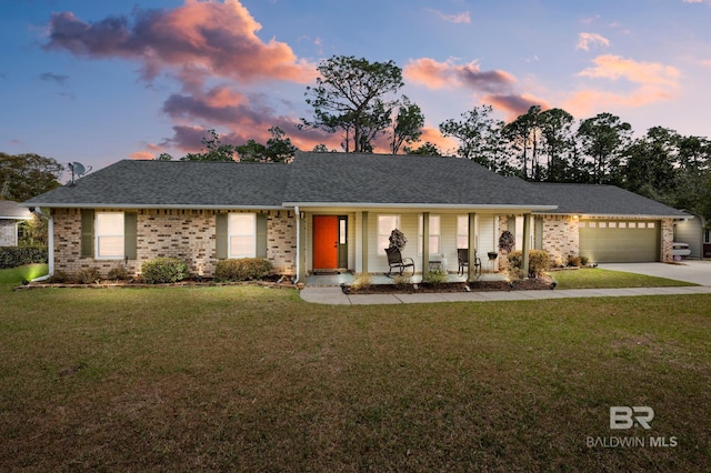 ranch-style house featuring a garage, brick siding, concrete driveway, roof with shingles, and a front yard