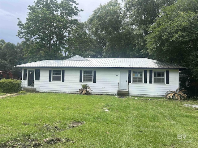 ranch-style home with entry steps, metal roof, and a front yard