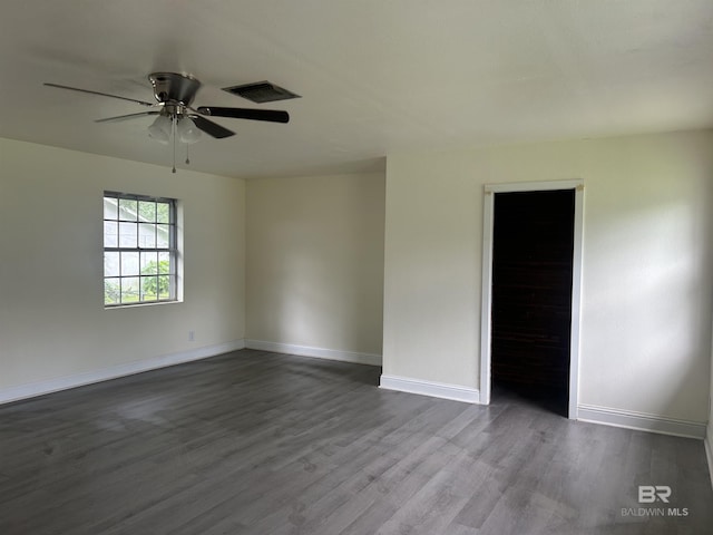 empty room with dark wood-type flooring, baseboards, and a ceiling fan