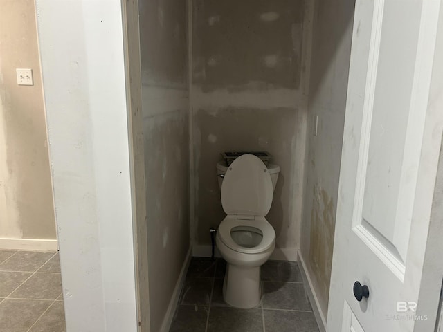 bathroom featuring tile patterned flooring, toilet, and baseboards