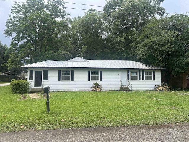 single story home featuring entry steps, a front yard, and metal roof