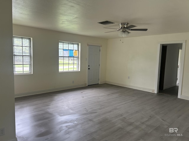 unfurnished room with wood finished floors, baseboards, and a ceiling fan
