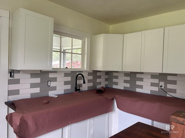 kitchen with backsplash and white cabinets