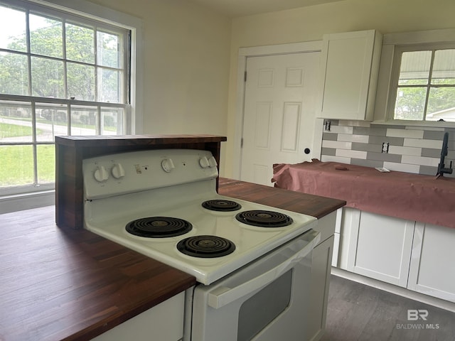 kitchen with white electric range, healthy amount of natural light, and white cabinetry