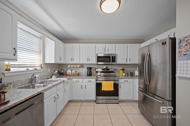 129 Oakwood Ave, Fairhope, AL 36532 - kitchen featuring appliances with stainless steel finishes, a sink, white cabinets, and a textured ceiling