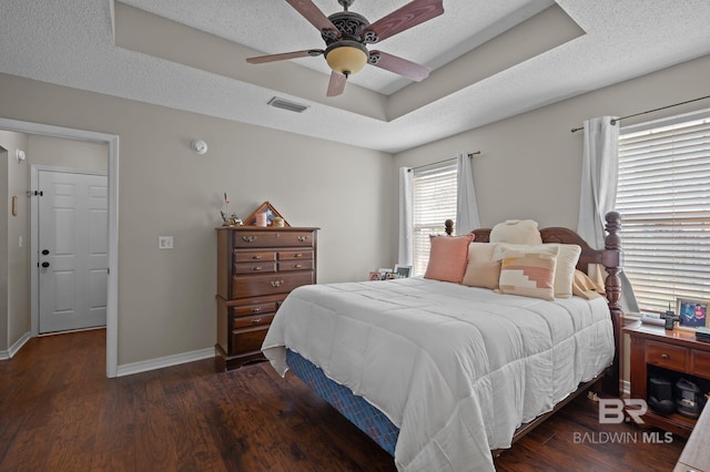 129 Oakwood Ave, Fairhope, AL 36532 - bedroom featuring a tray ceiling, wood finished floors, baseboards, a ceiling fan, and a textured ceiling
