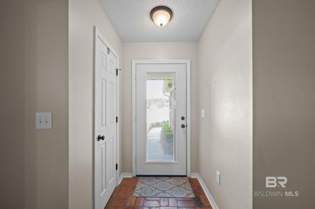 129 Oakwood Ave, Fairhope, AL 36532 - entryway with baseboards, brick floors, and a textured ceiling