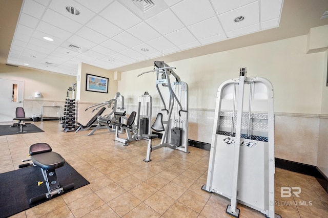 exercise room with visible vents, a drop ceiling, and light tile patterned floors