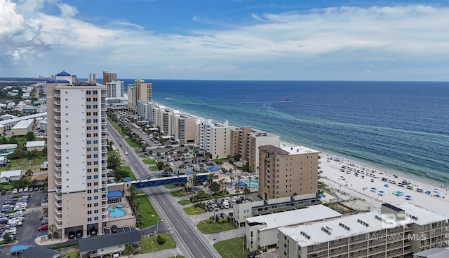 drone / aerial view featuring a water view, a view of city, and a beach view