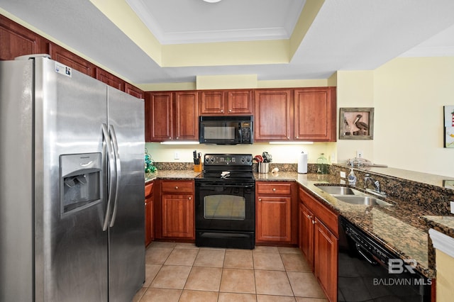 kitchen featuring a raised ceiling, ornamental molding, dark stone countertops, black appliances, and a sink