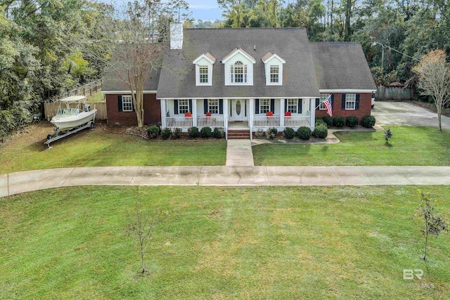 cape cod home with a chimney, fence, a porch, and a front yard