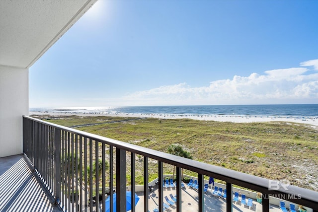 balcony featuring a view of the beach and a water view