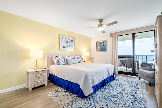 bedroom featuring access to exterior, light wood-style flooring, a ceiling fan, and baseboards