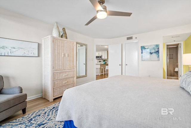 bedroom with visible vents, baseboards, wood finished floors, and a ceiling fan