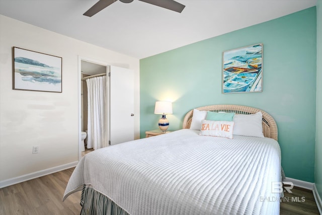 bedroom with a ceiling fan, ensuite bath, wood finished floors, and baseboards