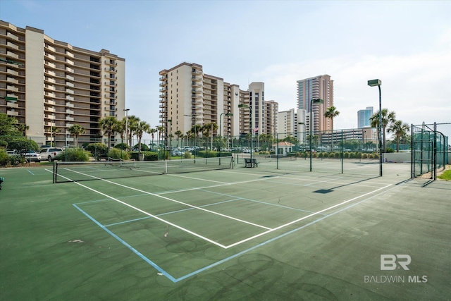 view of sport court featuring a view of city and fence