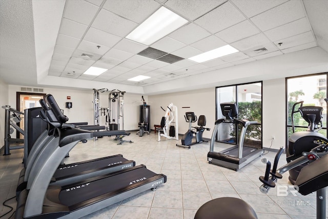 workout area with light tile patterned floors, visible vents, and a paneled ceiling