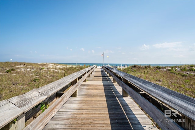 view of dock with a beach view and a water view