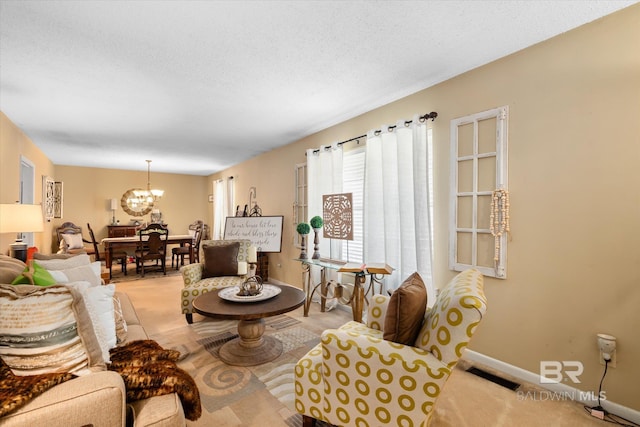 living room with light carpet, a textured ceiling, and a notable chandelier