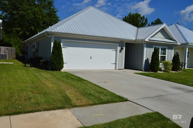 ranch-style house featuring a front lawn, central AC, and a garage