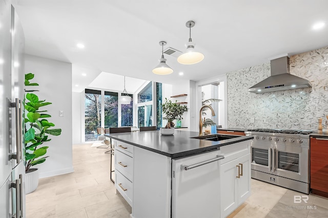 kitchen with dark countertops, high end stainless steel range oven, wall chimney exhaust hood, and white cabinets