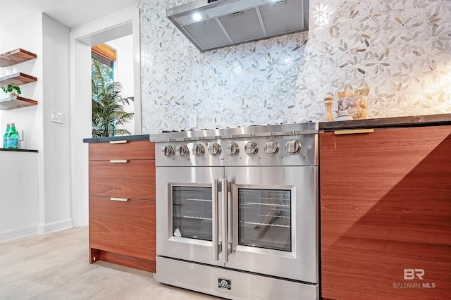 kitchen with dark countertops, stainless steel range oven, range hood, and wallpapered walls