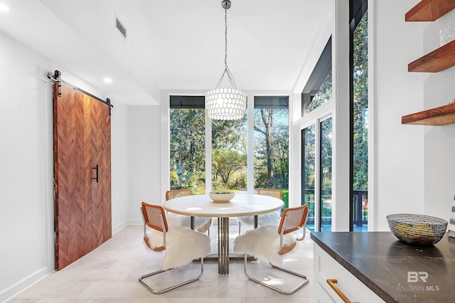 dining area featuring floor to ceiling windows, visible vents, light wood-style flooring, a barn door, and baseboards