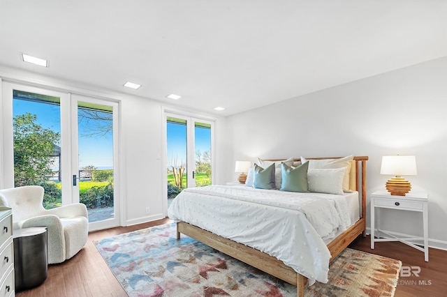 bedroom with access to exterior, baseboards, and dark wood-style flooring