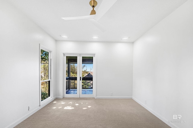 spare room featuring ceiling fan, baseboards, and light colored carpet