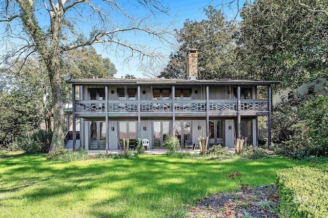 back of property featuring a chimney and a yard