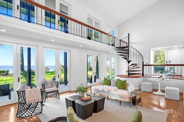 living area with stairway, a towering ceiling, and baseboards