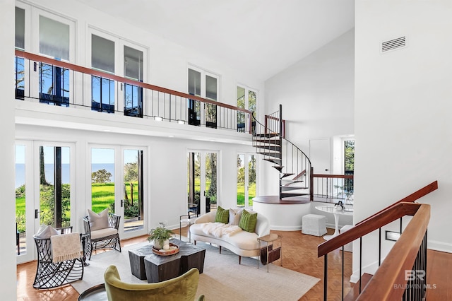 interior space with a towering ceiling, stairway, baseboards, and visible vents