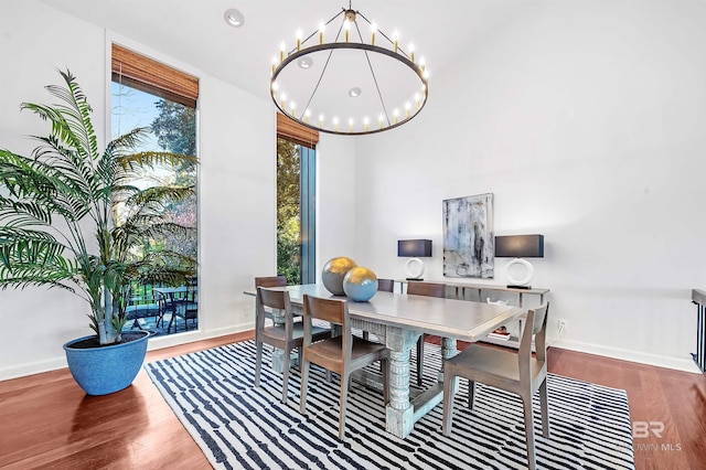 dining area with baseboards, a chandelier, and wood finished floors