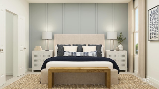 bedroom with a decorative wall, baseboards, and carpet floors