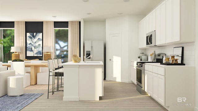 kitchen featuring light wood-type flooring, an island with sink, decorative backsplash, white refrigerator with ice dispenser, and stainless steel range