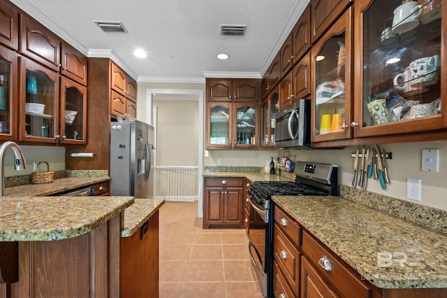 kitchen featuring kitchen peninsula, light tile patterned floors, appliances with stainless steel finishes, crown molding, and light stone counters