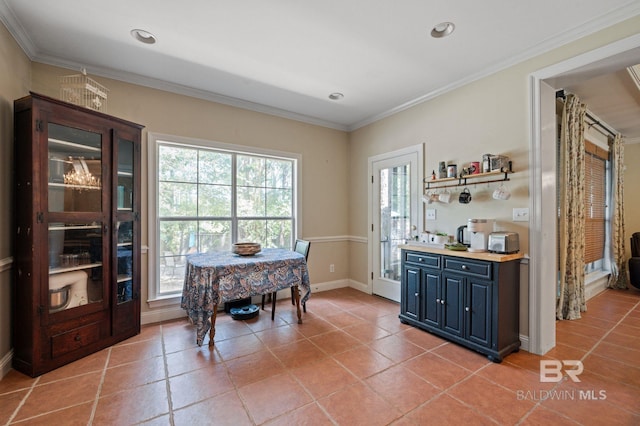 dining space featuring ornamental molding and light tile patterned flooring