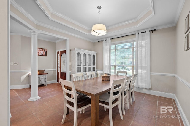 dining area with ornate columns, a raised ceiling, ornamental molding, and tile patterned floors