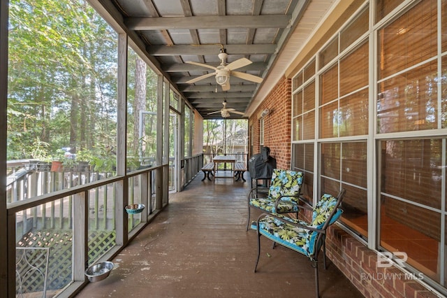 unfurnished sunroom featuring ceiling fan