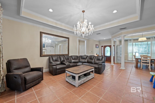 tiled living room with ornamental molding, a notable chandelier, ornate columns, and a raised ceiling