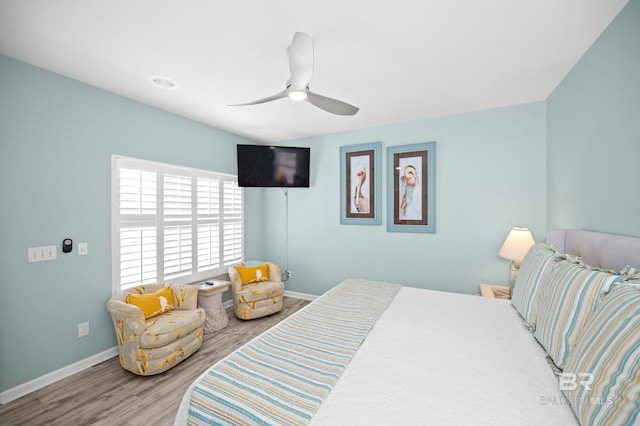 bedroom featuring baseboards, wood finished floors, and a ceiling fan