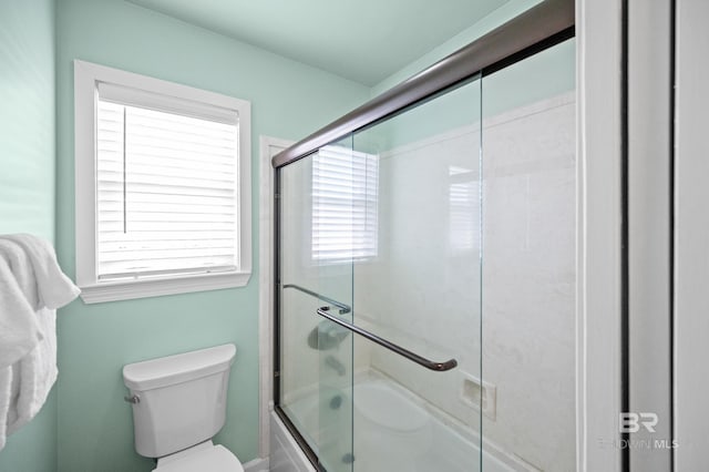 bathroom featuring toilet and enclosed tub / shower combo