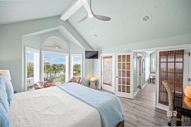 bedroom featuring a ceiling fan, lofted ceiling with beams, a textured ceiling, light wood finished floors, and baseboards