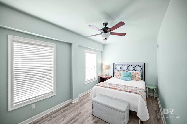 bedroom with wood finished floors, baseboards, and ceiling fan