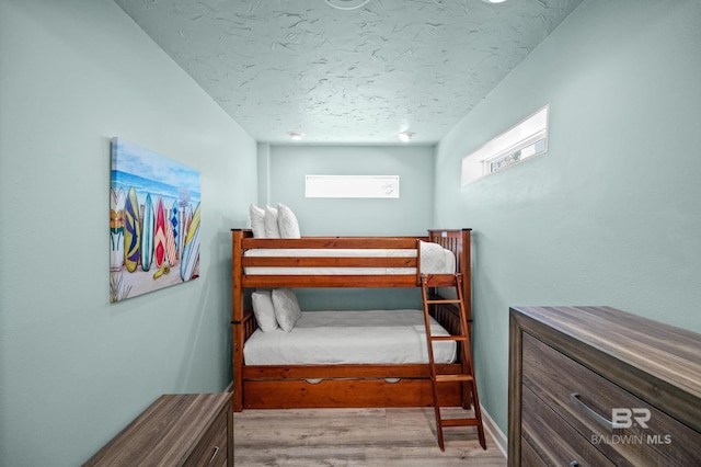 bedroom featuring wood finished floors and a textured ceiling