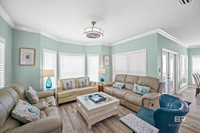 living room with light wood-type flooring, visible vents, ornamental molding, and french doors