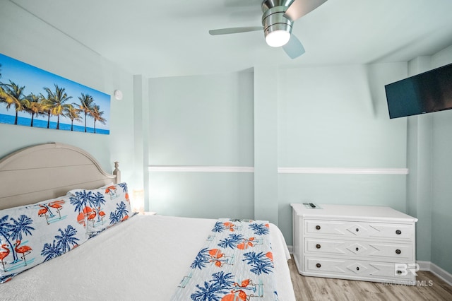 bedroom with ceiling fan, baseboards, and light wood-style floors