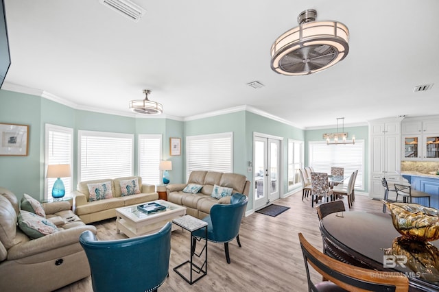 living room featuring visible vents, a healthy amount of sunlight, and light wood-style flooring